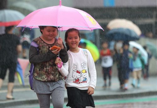 23일 제주지역에 가상특보가 발효되며 많은 비가 내린 가운데 서귀포시 서귀북초등학교 어린이들이 우산을 쓰고 하교하고 있다.
