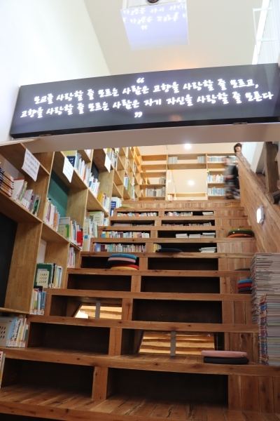 계단에 앉아 책을 볼 수 있는 '계단도서관'. 계단 위에는 도서관의 최초 설립자인 故 김영수 선생의 좌우명이 있다.
