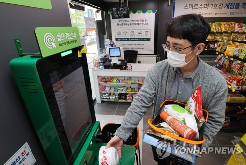 15일 오후 서울 동작구 사당동 한 동네 슈퍼마켓이 '스마트슈퍼' 1호점으로 개점, 관계자가 무인 계산대를 이용해 물품을 사는 과정을 시연하고 있다.