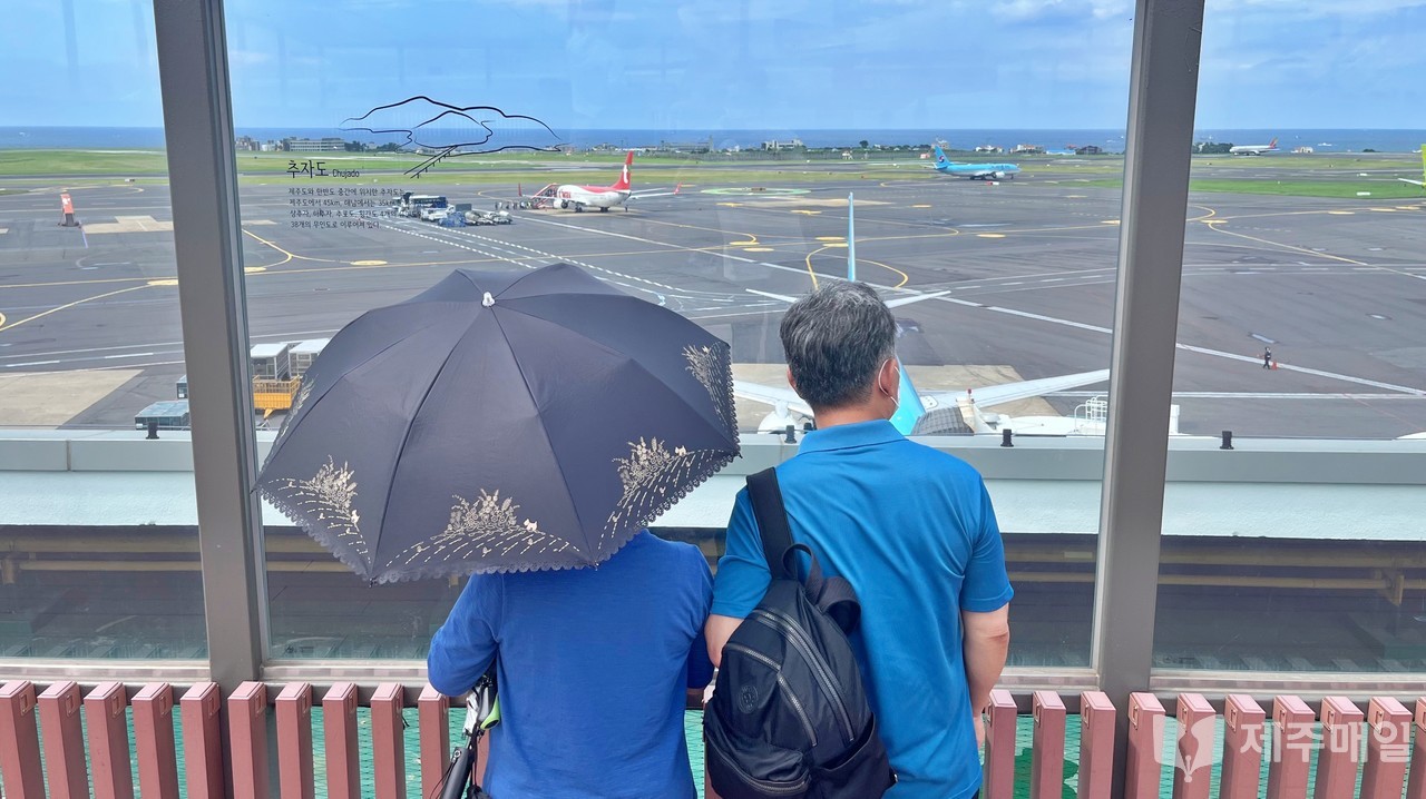 구름이 걷힌 2일 오후 제주를 찾은 관광객들이 제주국제공항 전망대에서 활주로를 이동해 이륙하는 항공기를 바라보고 있다.