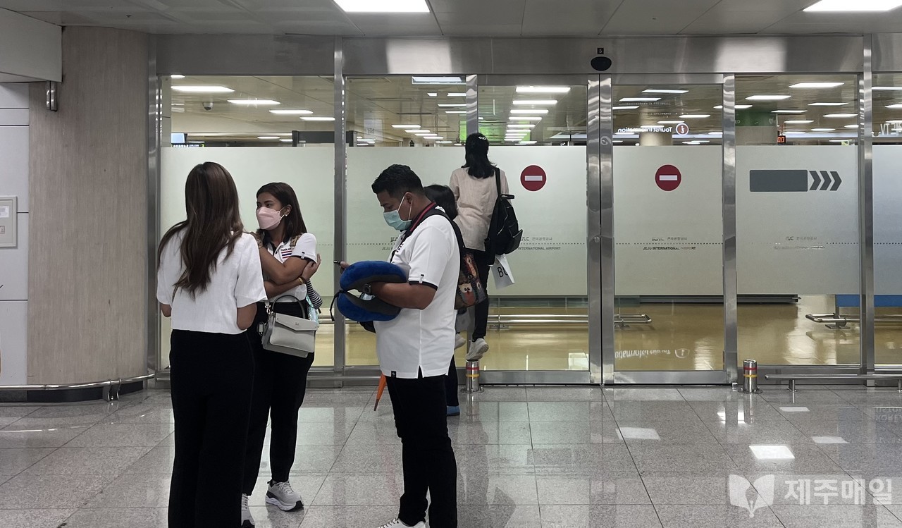 2일 오후 제주국제공항 입국장에서 대기중인 태국인 관광객 가이드들. 한 태국인 가이드가 입국장 안을 들여다보고 있다 .