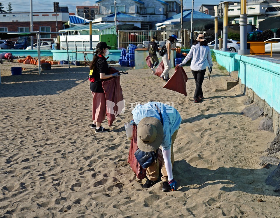 지난 7일 오전 제주시 이호테우해변에서 ‘지구별 플로깅’ 참가자들이 해변에 버려진 쓰레기들을 줍고 있다. [사진=조문호 기자]