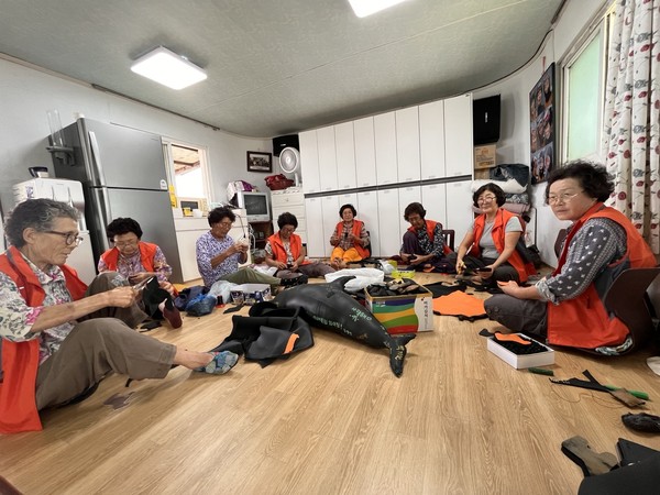 공드리연구소에 참여하고 있는 이호동해녀들이 22일 해녀탈의실에 모여 폐해녀복을 이용해 굿즈를 만들어내고 있다.