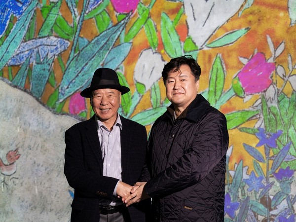 이왈종 화백(사진 왼쪽)과 박진우 ㈜티모넷 대표가 ‘이왈종, 중도의 섬 제주’전을 앞두고 기념촬영을 하고 있다.