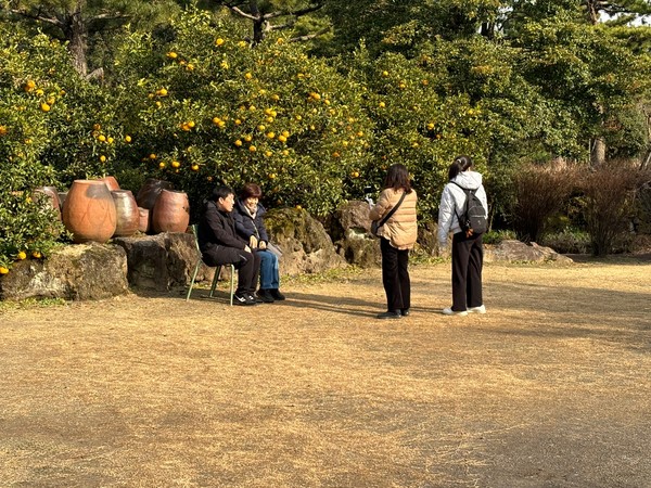 가족 단위 관람객들이 휴애리에 마련된 포토존에 앉아 기념사진을 찍고 있다.