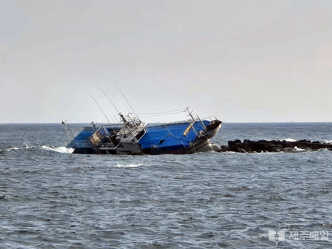 지난 24일 밤 서귀포시 대정읍 인근 해상에서 암초에 걸려 좌초된 한림선적 근해연승 어선 A호(20t급)가 1일 오후 만조 가까이 된 시각 사고 당일보다 더 우현으로 귀울어진 채 놓여 있다. [사진=조문호 기자]