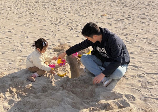 윤은주씨의 딸과 남편이 모래놀이를 하고 있다.