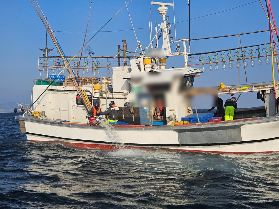 서귀포해경이 침수 중인 선박에 올라 배수작업을 벌이고 있다. 