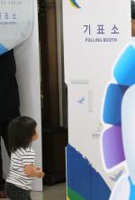 제10회 전국동시지방선거 투표일인 4일 신광초등학교에 마련된 투표소를 찾은 한 아이가 투표하는 모습을 지켜보고 있다. 