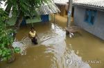 18일 스리랑카 수도 콜롬보 외곽 켈라니아에서 한 여성이 물에 잠긴 길을 가고 있다.(AFP=연합뉴스)
