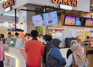 자카르타의 대형쇼핑몰에서 큰 인기를 끌고 있는 한국식품 매장에 줄을 서서 기다리는 인도네시아 젊은이들.