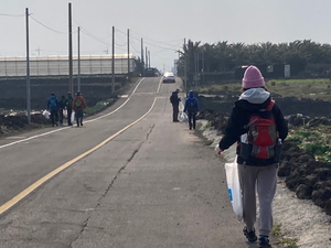 ’그린올레’ 캠페인에 참여한 도보여행자들이 쓰레기를 수거하며 올레길을 걷고 있다.
