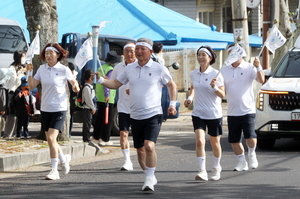 표선초등학교에서 김용우 표선면체육회 자문위원이 성화를 봉송하고 있다.